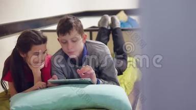 男孩和女孩在玩平板电脑。兄妹儿童社交媒体网络游戏室内平板电脑